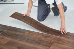 Worker joining vinyl floor covering at home renovation - Deerfoot Carpet