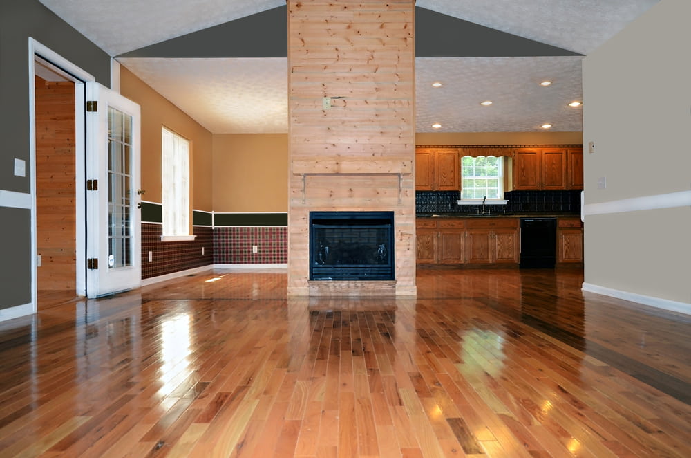 Empty living area with a fireplace calgary hardwood flooring