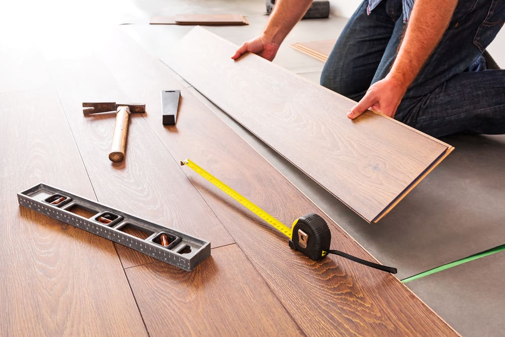 Man installing new laminated wooden floor home flooring calgary
