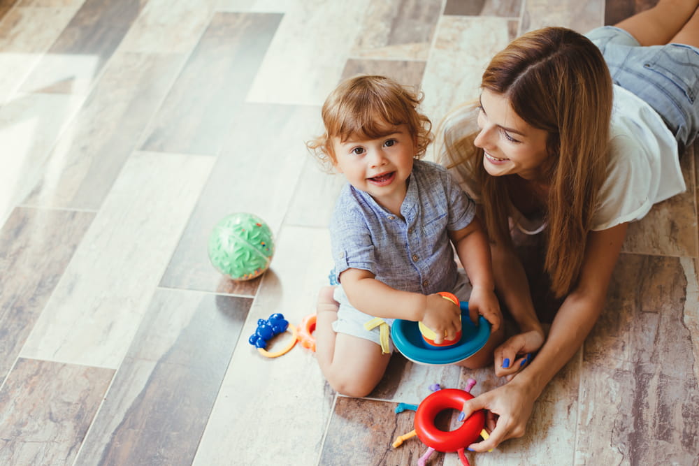 Mom playing with her son vinyl vs laminate flooring comparison