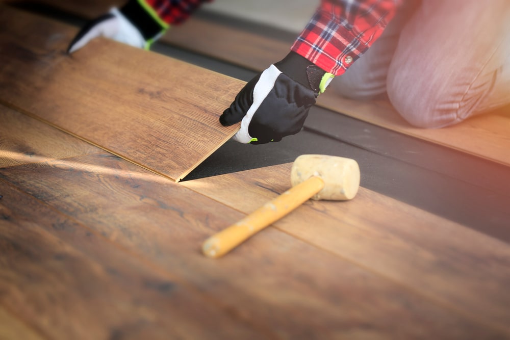 Worker hands installing calgary hardwood flooring